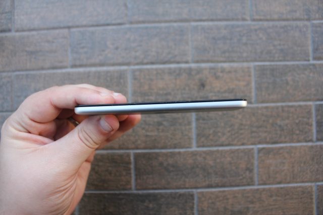 Handheld electronic device against a brick background.