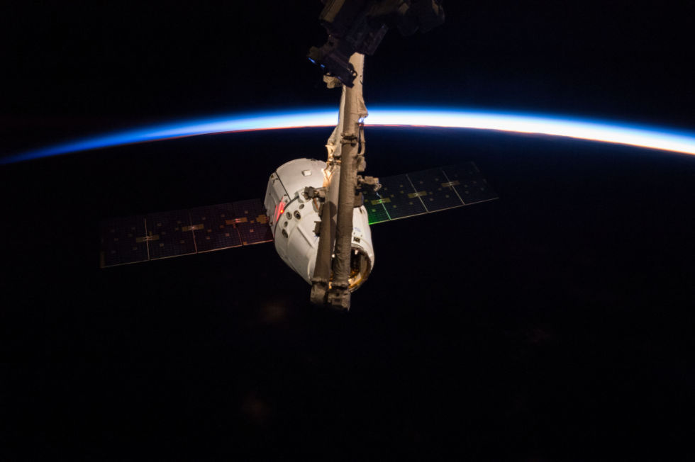 A robotic arm grabs SpaceX's Dragon spacecraft in 2015.