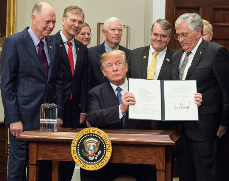 President Donald Trump holds up the Presidential Space Directive-1 after signing it.