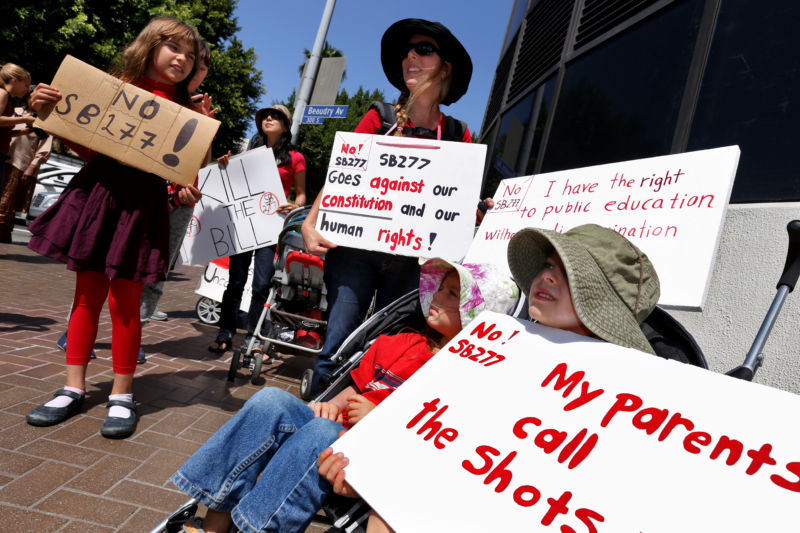 Los Angeles, California - April 14, 2015: Anna Audis, 10, and Monica Van Stelton with her children join other parents and teachers in resisting efforts to end the personal faith exemption at vaccination rallies.
