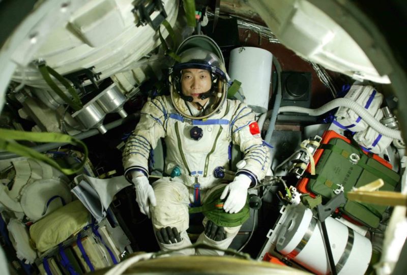 Astronaut Yang Liwei lies in the re-entry capsule of Shenzhou-5 Spacecraft during a training on September 27, 2003 in Beijing, China.