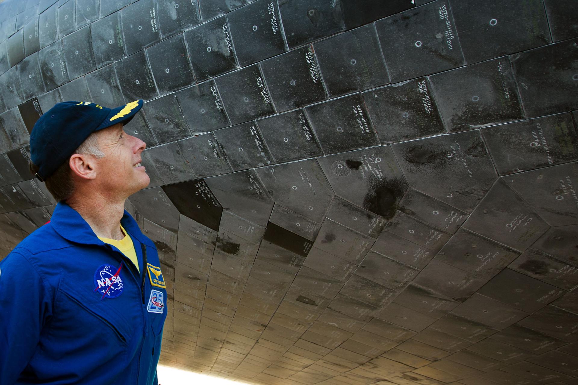 Chris Ferguson, commander of STS-135, examines the orbiter's thermal tiles after the space shuttle Atlantis completed the final mission of NASA's shuttle program in 2011.
