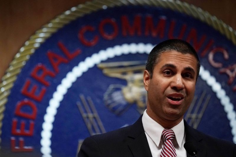 Le président de la FCC, Ajit Pai, debout devant le sceau de la FCC et s’adressant aux journalistes.