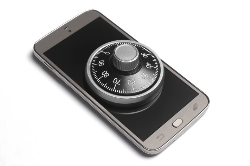 A combination lock sitting on top of a smartphone.