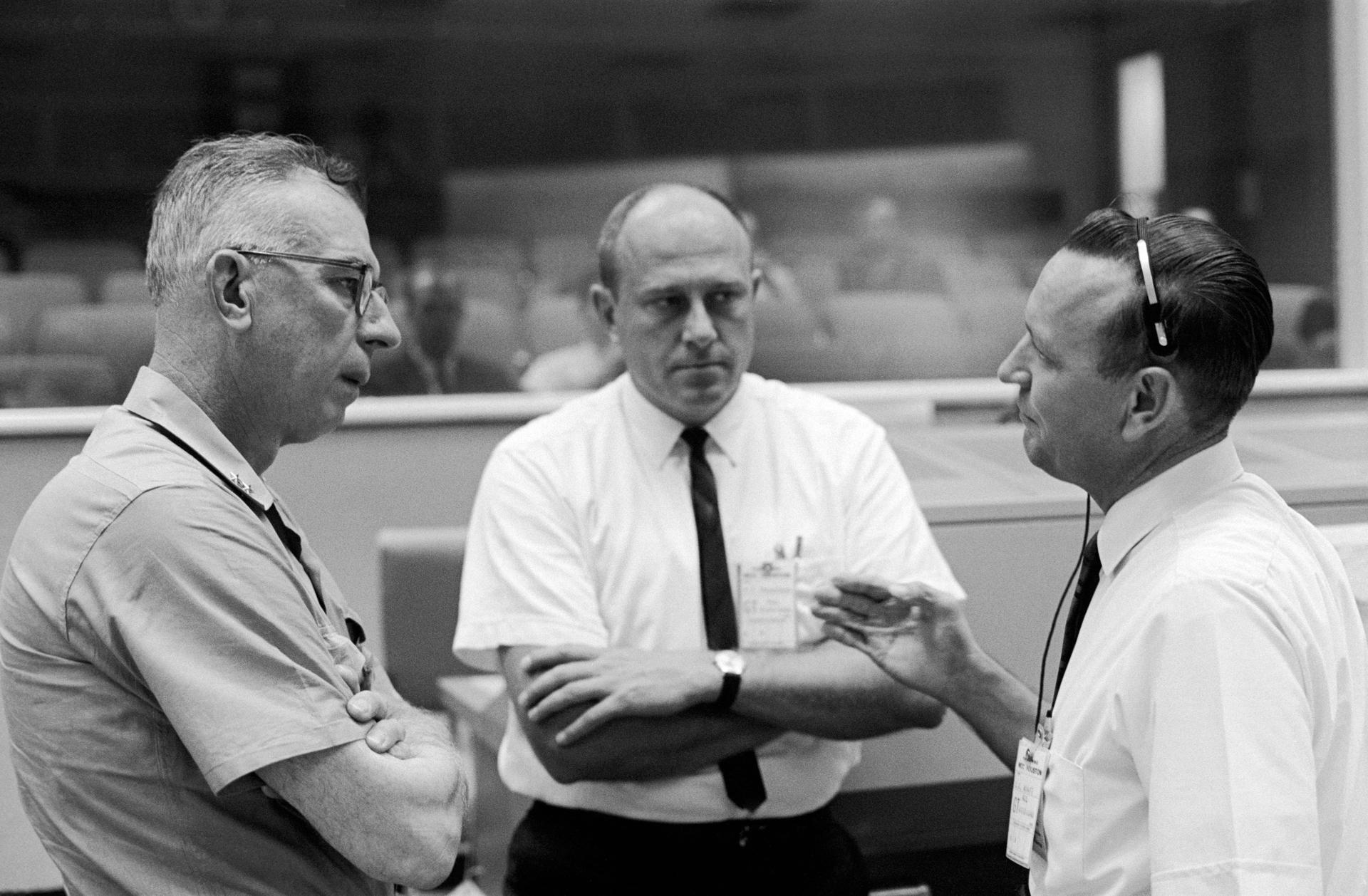 In 1965, Rear Admiral W.C. Abhau (left), is shown in the Mission Control Center with Bob Thompson (center) and Chris Kraft, flight director for Gemini-5.