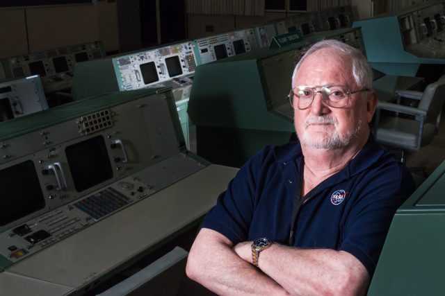 Seymour "Sy" Liebergot in MOCR2, with EECOM console highlighted in background.