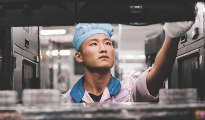 An iPhone assembly worker works with Apple supplier Pegatron in an image distributed by Apple.