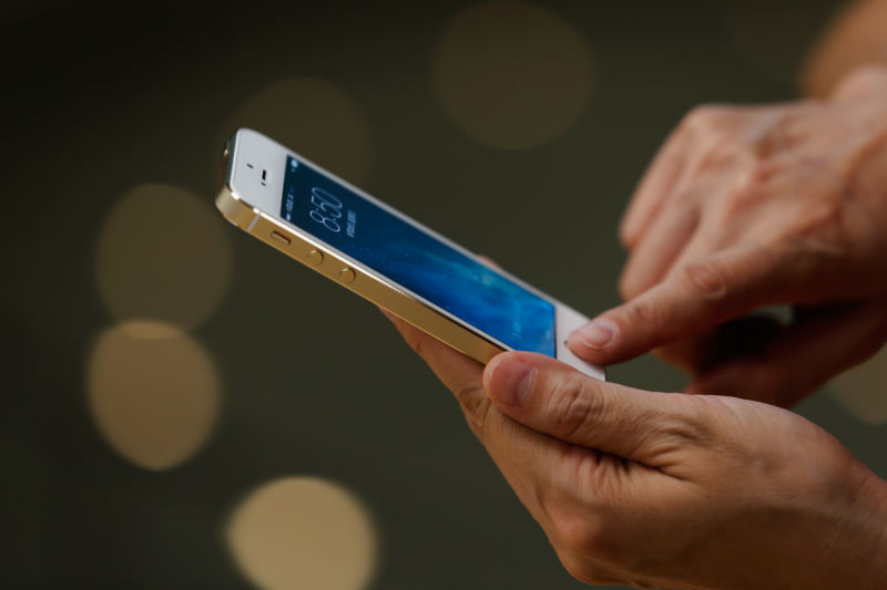 A customer inspects the new iPhone at the Wangfujing flagship store on September 20, 2013 in Beijing, China.