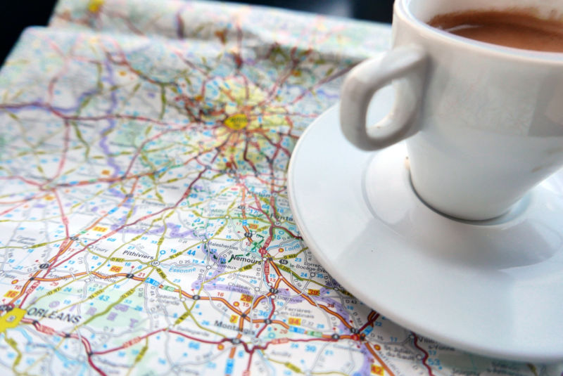 Close-Up Of Coffee With Map On Table
