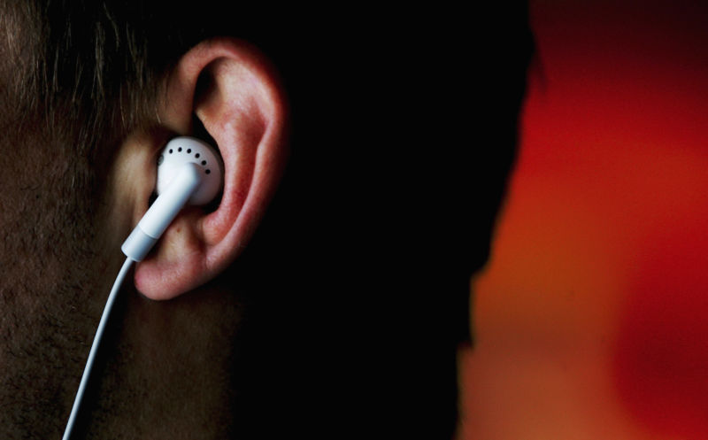 A close-up image of a person wearing ear buds.