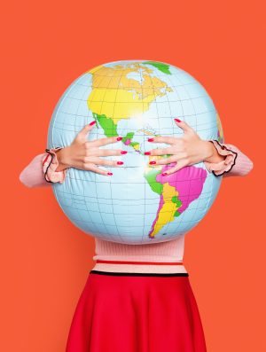 Large inflatable globe getting hugged by a woman in a red skirt.