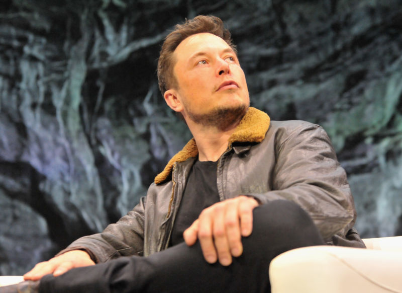 Elon Musk holds court in a leather bomber jacket.