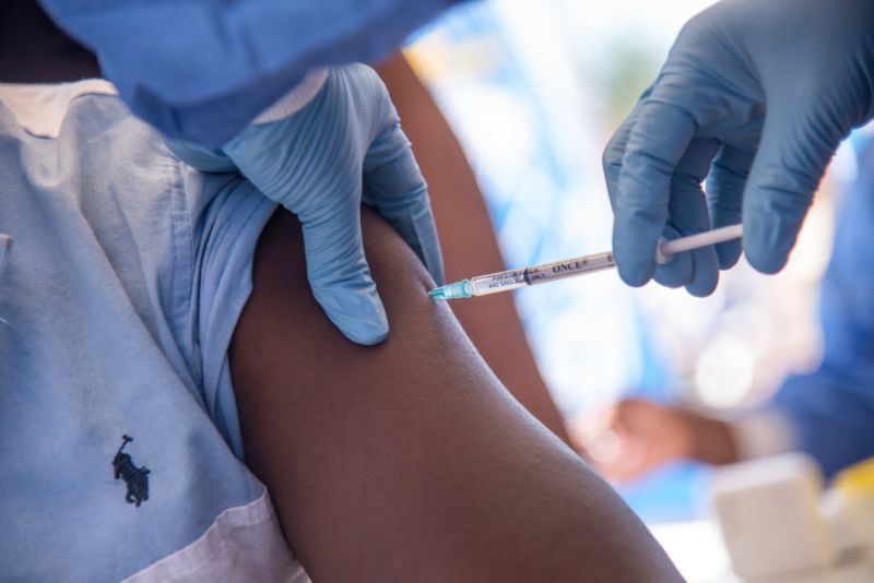 A close-up of an Ebola vaccine being injected into the arm of a doctor