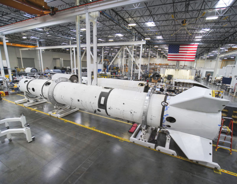 A late May view of the Virgin Orbit factory floor showing an essentially complete LauncherOne in the middle ground, lacking only the payload fairing. This booster will be used for captive carry and drop testing.