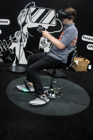 A man sits with funny shoes on a swivel chair