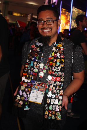 A man with a variety of gaming pins on his scarfs