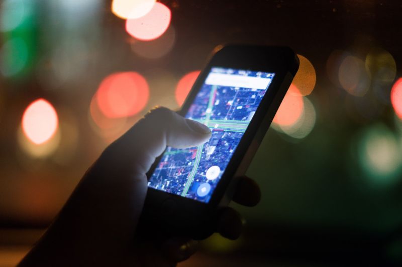 A person's hand holding a smartphone that is displaying a map.