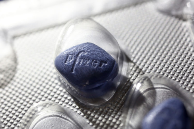 A close-up of a blue Viagra table with the Pfizer logo on their surface.