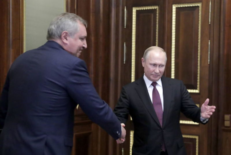 Russia President Vladimir Putin and former Deputy Prime Minister Dmitry Rogozin shake hands during a meeting at the Konstantin Palace.