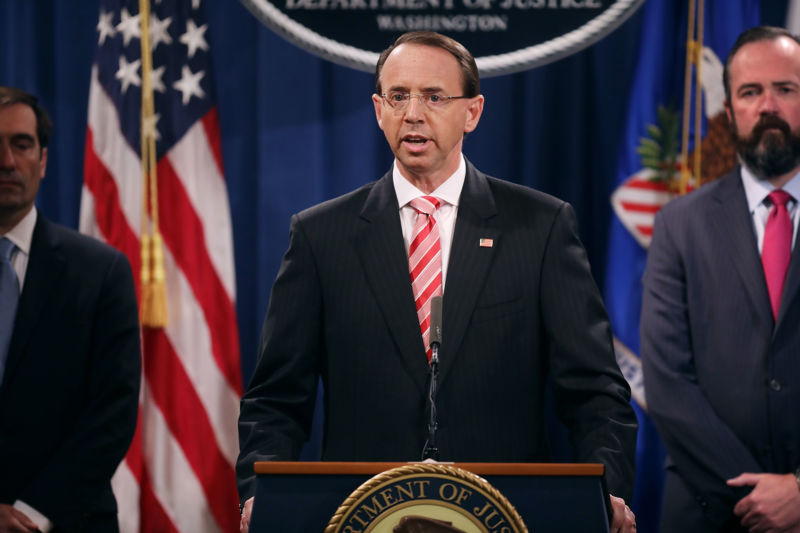 US Deputy Attorney General Rod Rosenstein (C) holds a news conference at the Department of Justice July 13, 2018 in Washington, DC. Rosenstein announced indictments against 12 Russian intelligence agents for hacking computers used by the Democratic National Committee, the Hillary Clinton campaign, the Democratic Congressional Campaign Committee and other organizations.