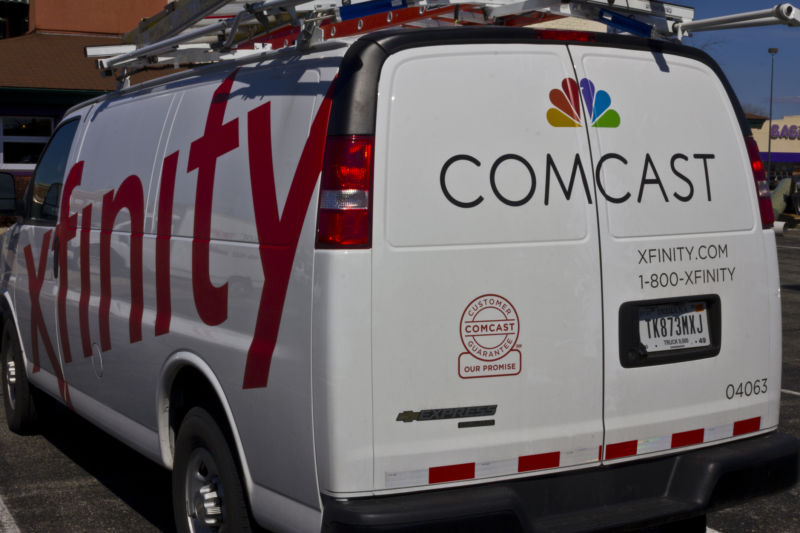 A Comcast service van covered in logos.