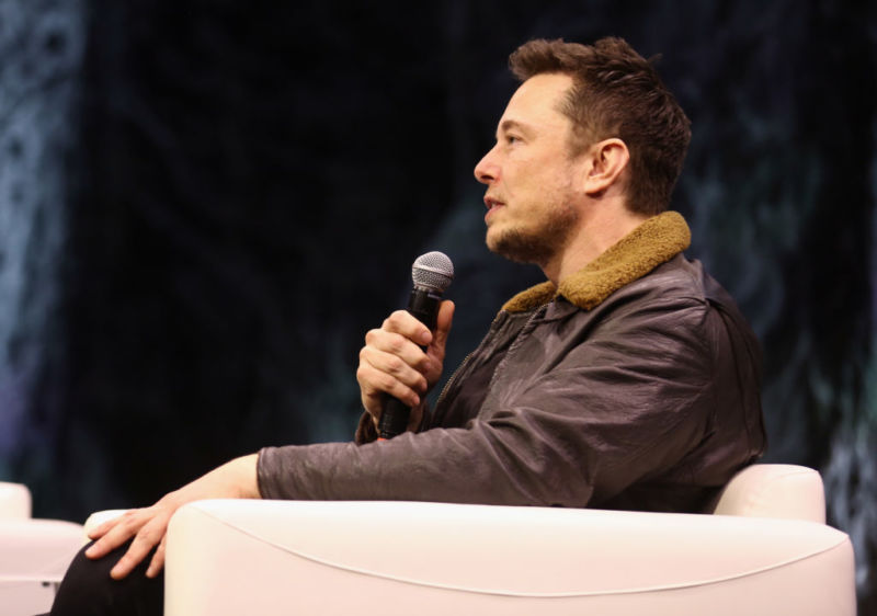 Elon Musk sitting down and speaking at a conference.