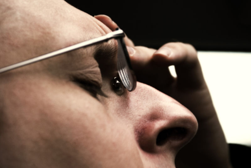 Image of a man clutching his forehead.