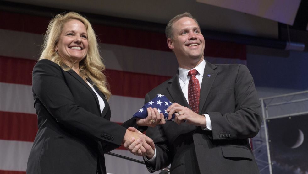 SpaceX President and COO Gwynne Shotwell receives an American flag from NASA Administrator Jim Bridenstine during a NASA event in Houston to announce astronaut crews.