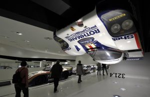 People walk past a Porsche 956 race car in the Porsche museum in Stuttgart, southern Germany
