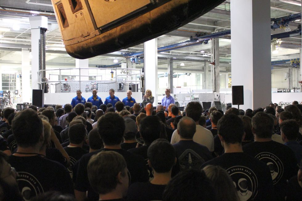 Four astronauts, Gwynne Shotwell, and Benjamin Reed on stage inside the SpaceX factory Monday.