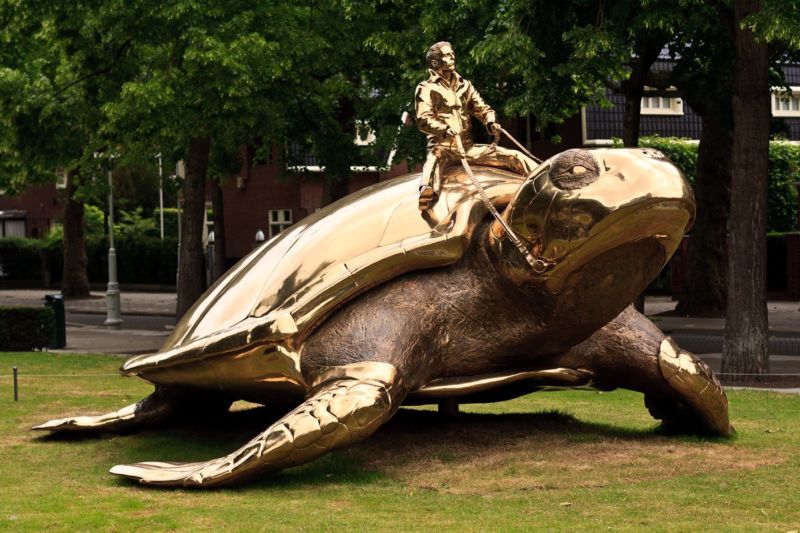 A sculpture of a man riding a turtle.