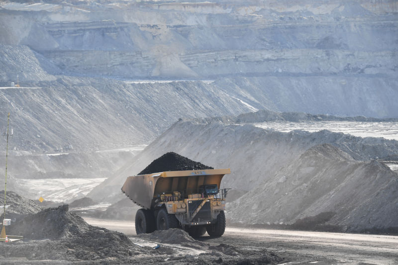 Dumptruck full of coal drives through strip mining area.