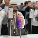 Smartphones on display at a crowded convention.