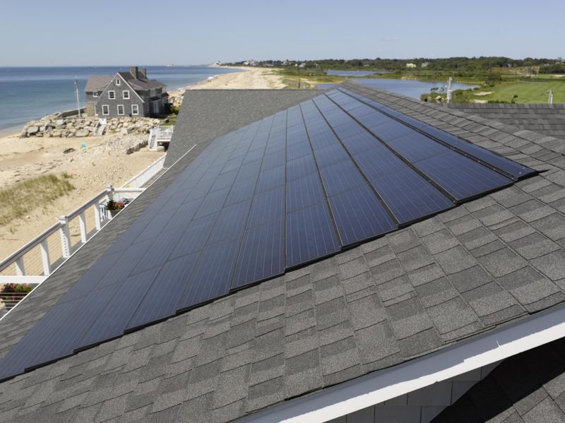 view of solar shingles and a beach