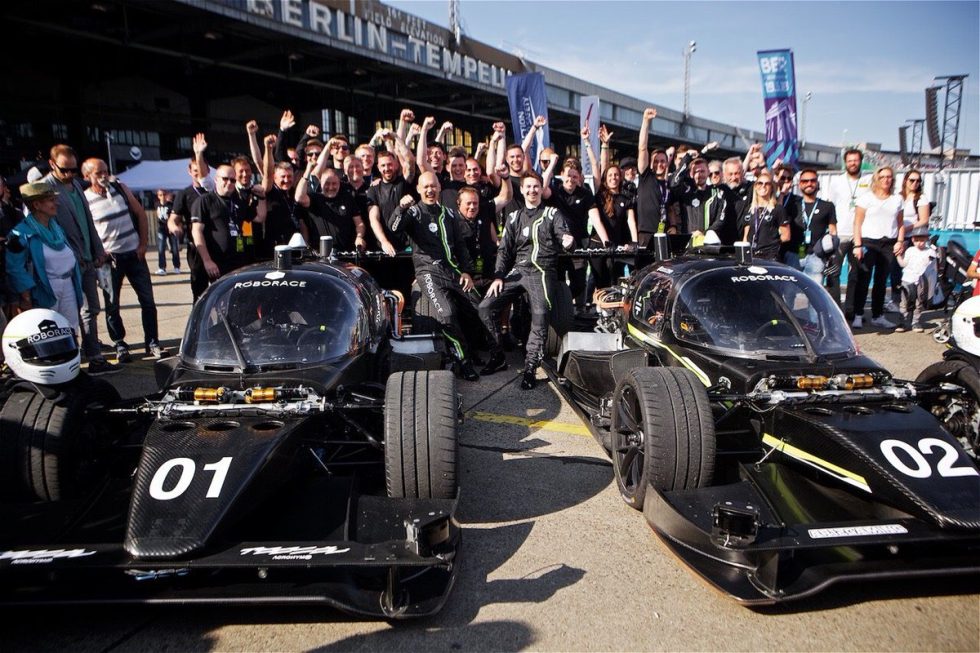 The Roborace teams celebrate after the first successful human+machine race.