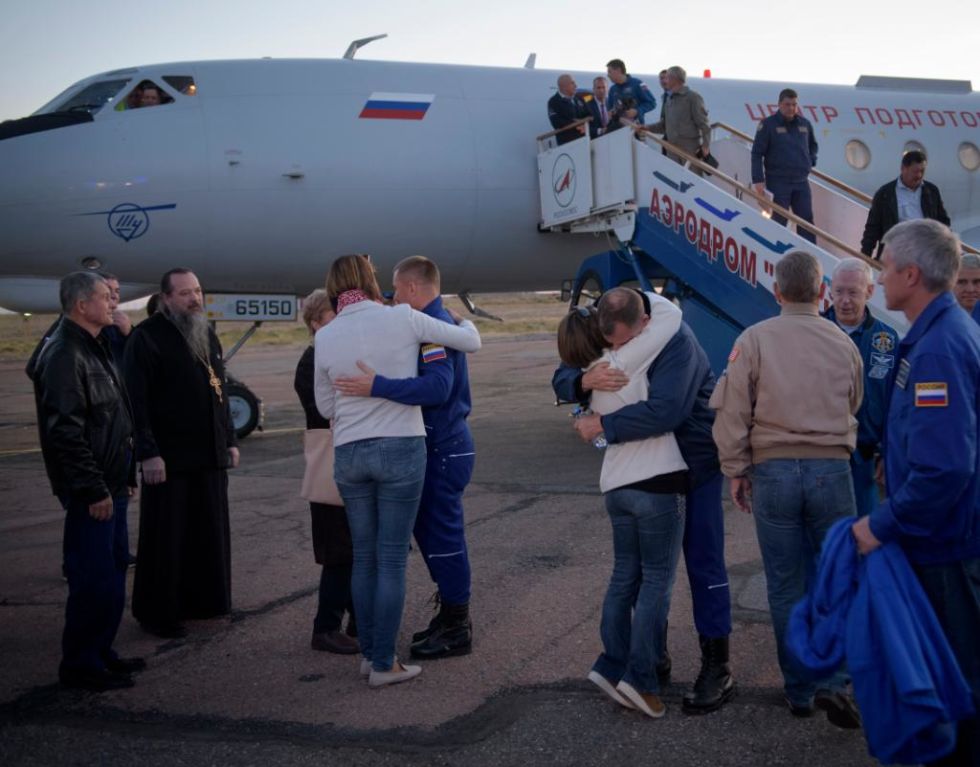 Astronaut Nick Hague, right, and cosmonaut Alexey Ovchinin, left, embrace their families after landing in Baikonur, Kazakhstan, on Thursday.