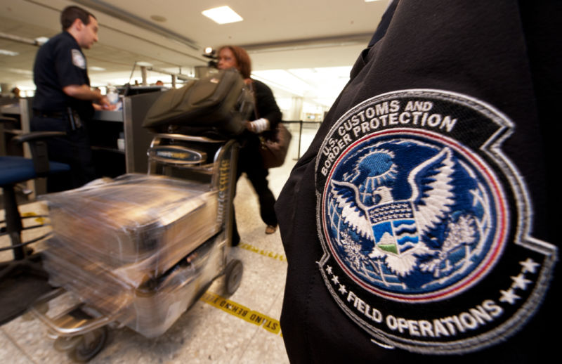 An international air traveler is cleared by a US Customs and Border Protection Officer (L) and is approved to enter the United States inside the US Customs and Immigration area at Dulles International Airport (IAD) , December 21, 2011 in Sterling, Virgina, near Washington, DC. 