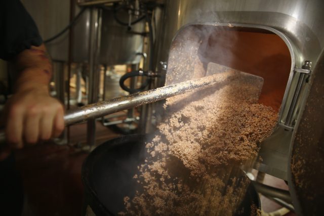 No barley, no beer: A beer brewer pulls malted barley from the mash tun at Wynwood Brewing Company in Miami, Florida.