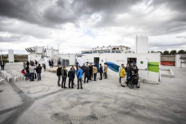 People milling about Climeworks' new plant in Troia, Italy.