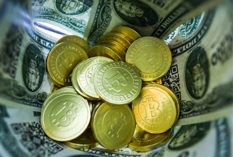 Stack of bitcoins and dollar bills