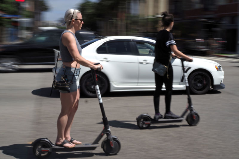People ride shared electric scooters in Santa Monica, California, on July 13, 2018. 