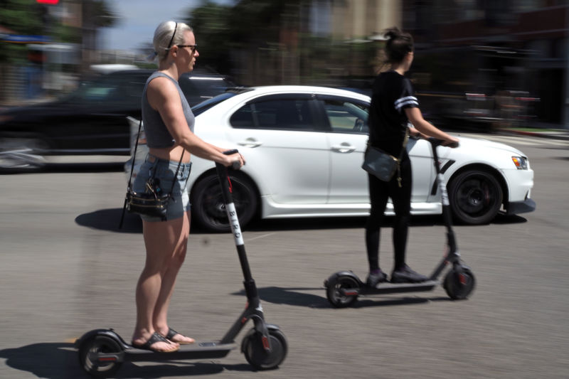 Des personnes utilisent des scooters électriques partagés à Santa Monica, en Californie, le 13 juillet 2018. 