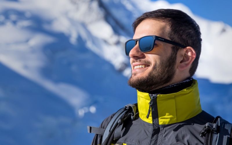 Dude enjoying winter sports in sunglasses is happy.