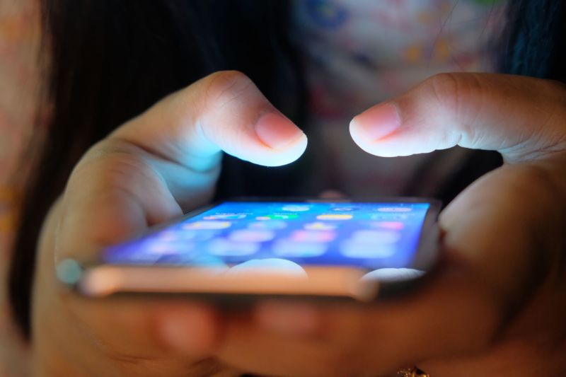 A woman's hands holding a mobile phone.