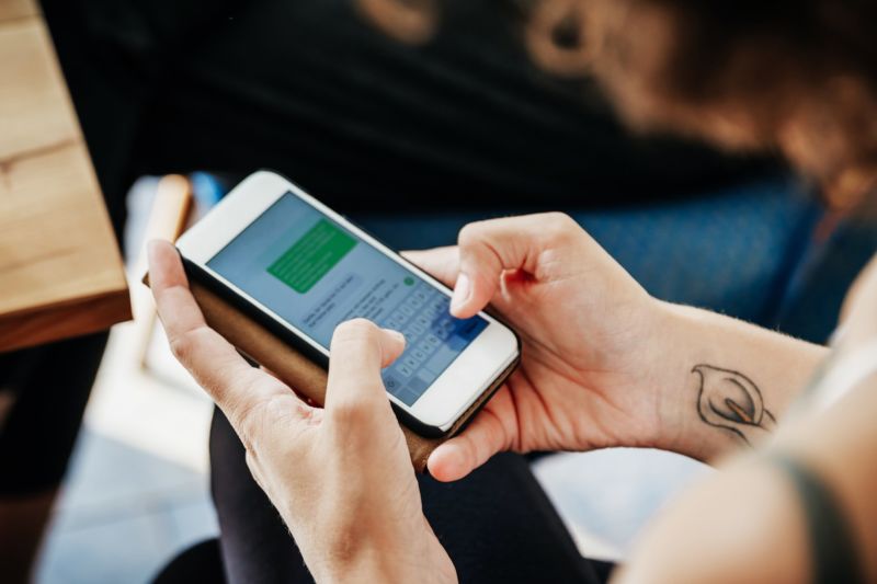 A woman sending a text message on a smartphone.