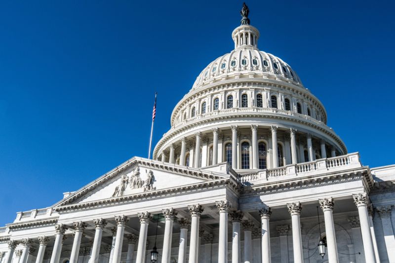 The dome of the United State Capitol Building against a deep blue sky in Washington, DC.