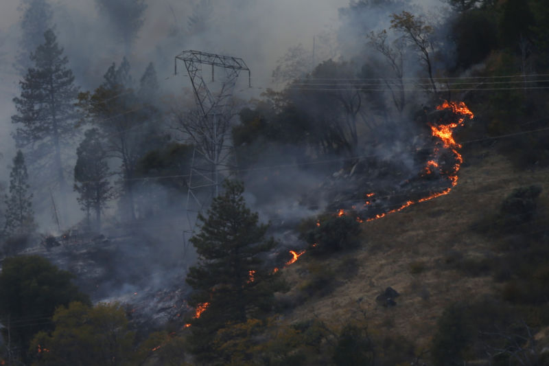 PG&E transmission tower surrounded by fire.