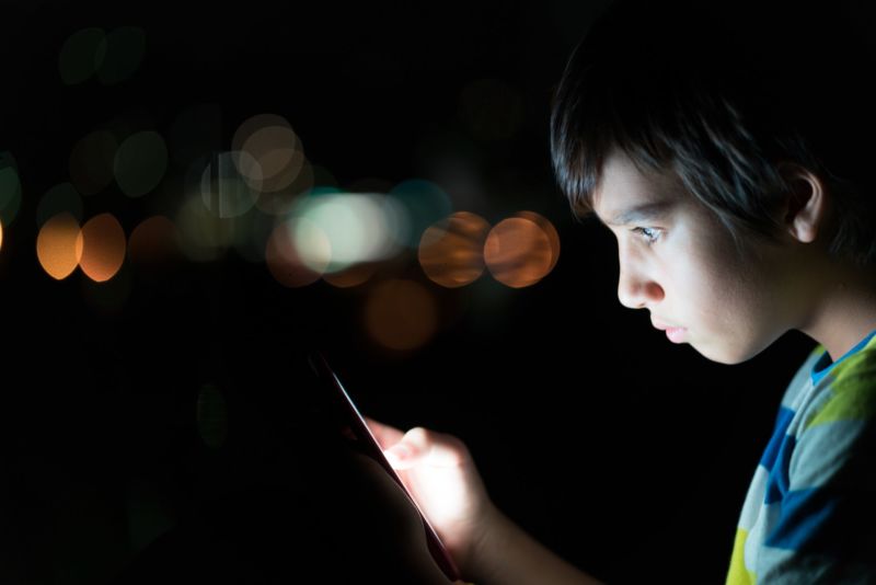 A boy looking at a smartphone.