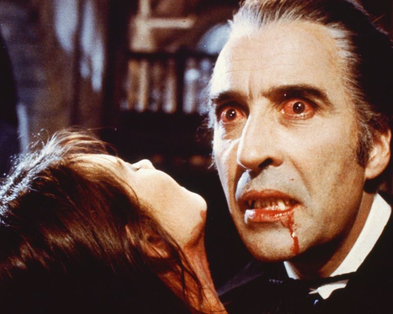 Fixed image of a Hammer horror movie in which a vampire (Christopher Lee) sucks blood from a pretty female victim.