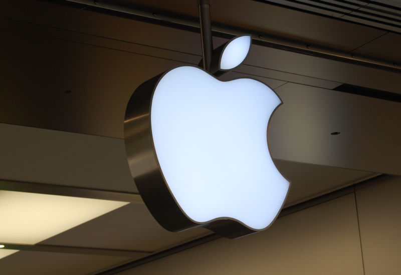 El logo de Apple toma forma corpórea afuera de una tienda Apple.